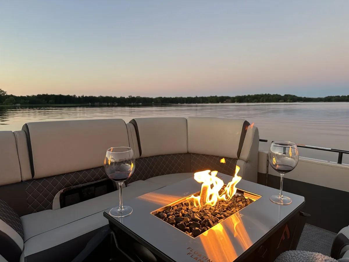Two glasses of wine beside the Floating Flame at dusk